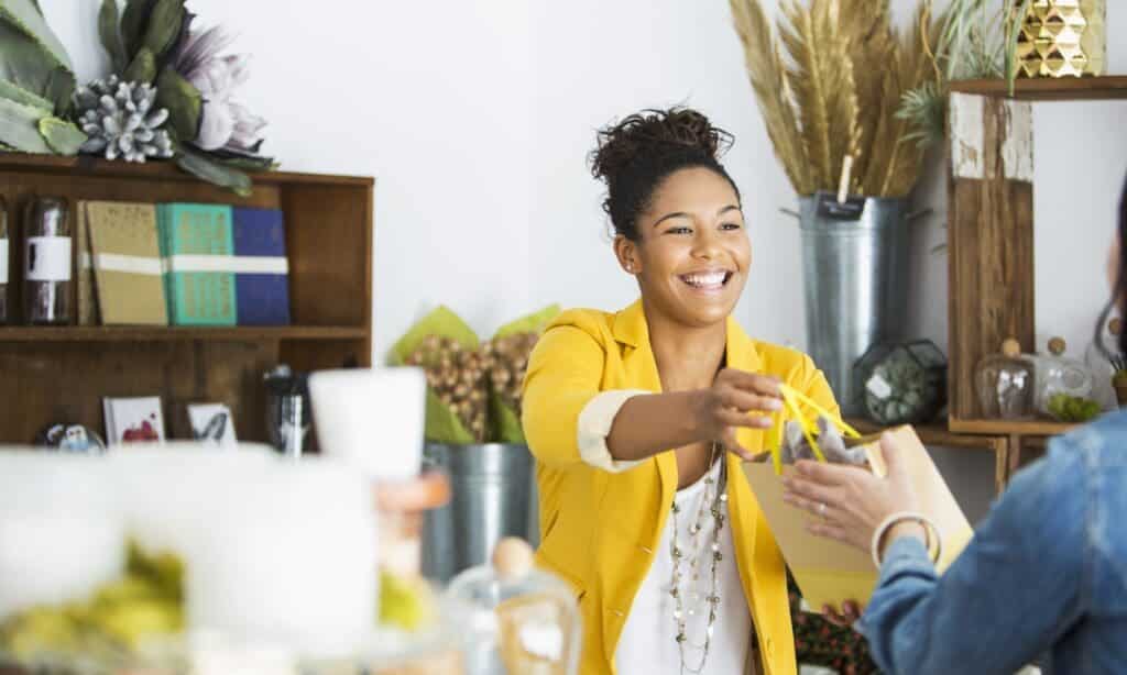 Business owner standing confidently with a clipboard in a modern, well-lit café, with a message about new California law and compliance.
